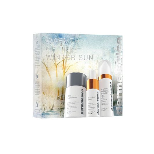 Das Warmth of the Winter Sun Set enthält drei essentielle Hautpflegeprodukte in weißen Flaschen, darunter ein Vitamin-C-Serum und SPF 50, in einer winterlichen Box - ideal als Glow & Schutz Travel-Set.