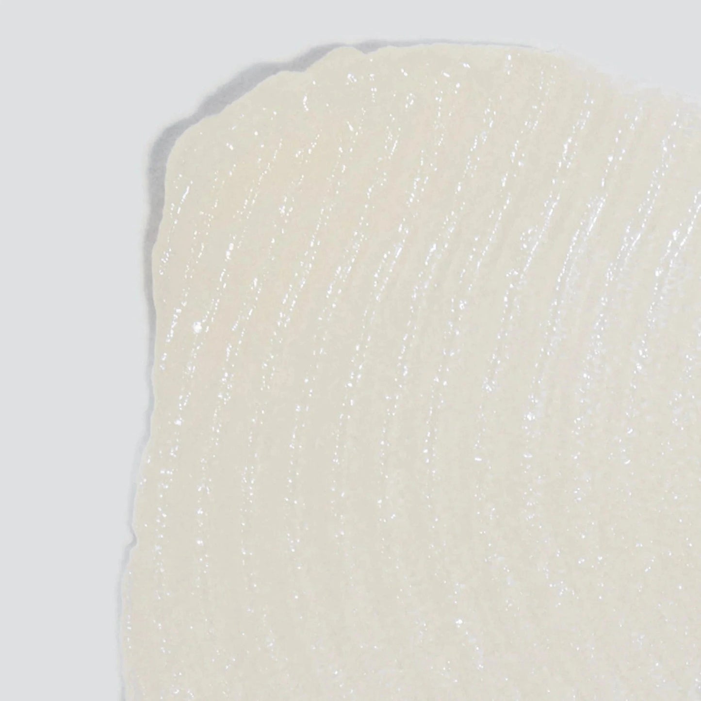 Nahaufnahme einer strukturierten, durchscheinend weißen Oberfläche mit geschwungenen Linien, die an Renewal Lip Complex 1,7 ml | Lippenpflege erinnert, angereichert mit Hyaluronsäure zur wohltuenden Pflege.