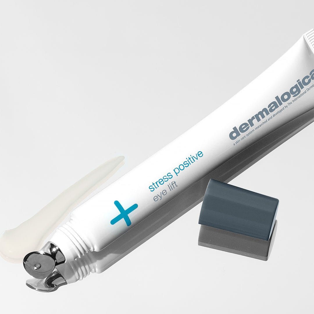 Eine Tube Stress Positive Eye Lift ohne Deckel und etwas Creme daneben auf einem weißen Untergrund – perfekt für die Augenpflege mit Lifting-Effekt.