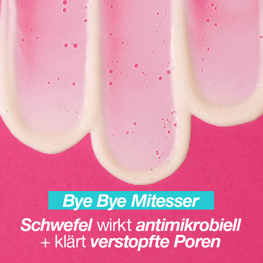 Drei Streifen einer pinkfarbenen Creme auf einem fuchsiafarbenen Hintergrund