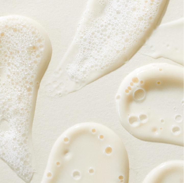 Verschiedene Tropfen und Kleckse einer cremigen, weißen Flüssigkeit