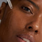 Nahaufnahme einer Person, die das Circular Hydration Serum mit einer Pipette auf ihre Wange aufträgt; ihre Haut und Gesichtszüge sind deutlich zu erkennen.