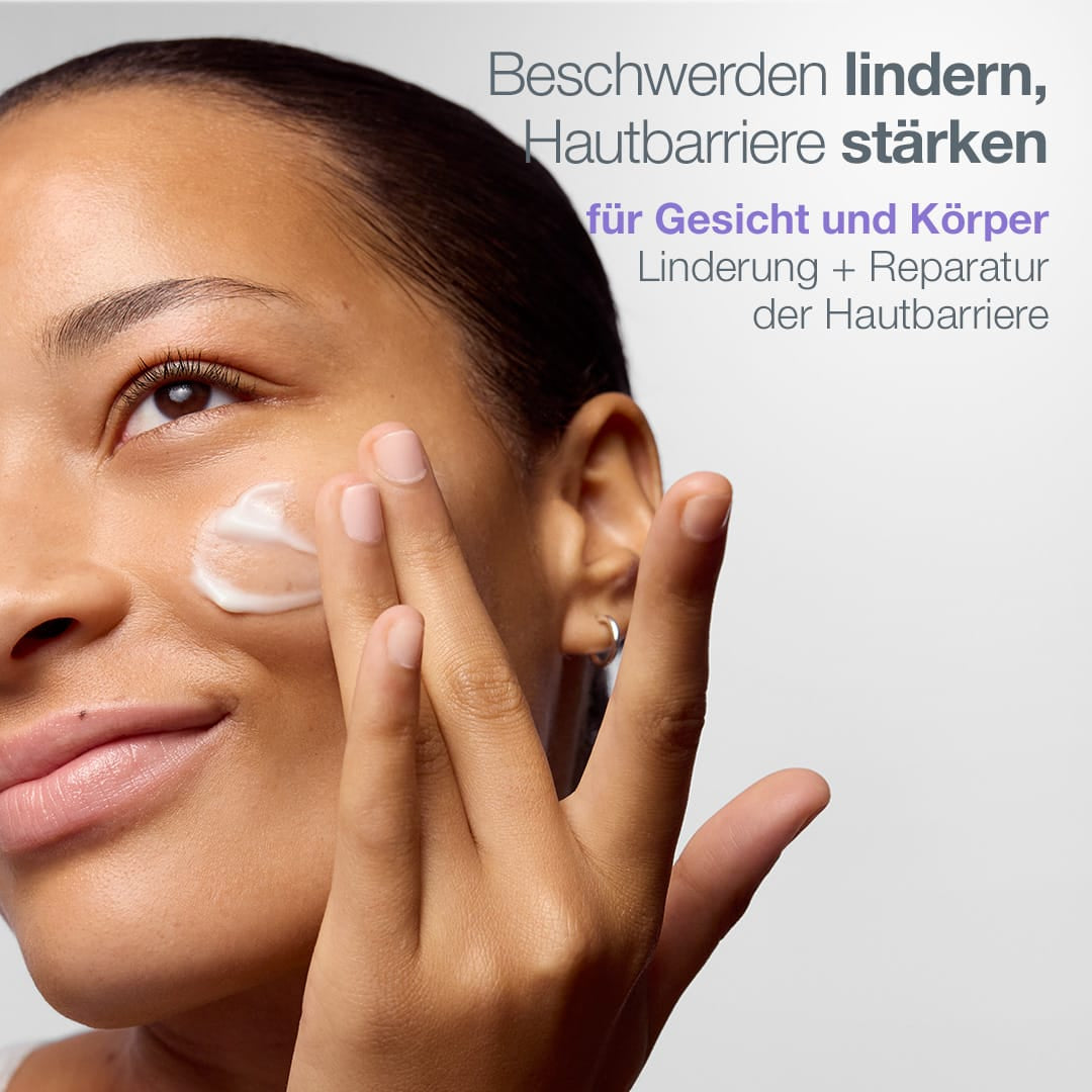 Eine Person trägt das „Stabilizing Repair Serum“ mit kolloidalem Hafermehl auf ihre Wange auf, wodurch die Hautbarriere gestärkt wird und eine beruhigende Wirkung erzielt wird, wie im deutschen Text hervorgehoben wird.
