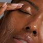 Mit geschlossenen Augen trägt eine Person mit der Fingerspitze zunächst PreCleanse und anschließend das Special Cleansing Gel auf ihr Gesicht auf, wobei glatte Haut und gepflegte Nägel zum Vorschein kommen.