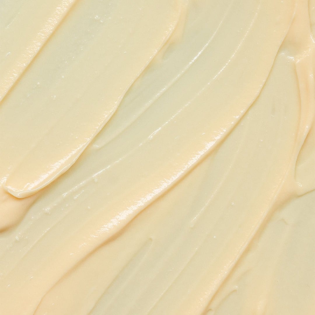 Nahaufnahme einer glatten, cremigen, hellgelben Substanz, die in strukturierten Wirbeln verteilt ist und der luxuriösen MultiVitamin Power Recovery Masque ähnelt, die für ihre antioxidative und Anti-Aging-Wirkung bekannt ist.