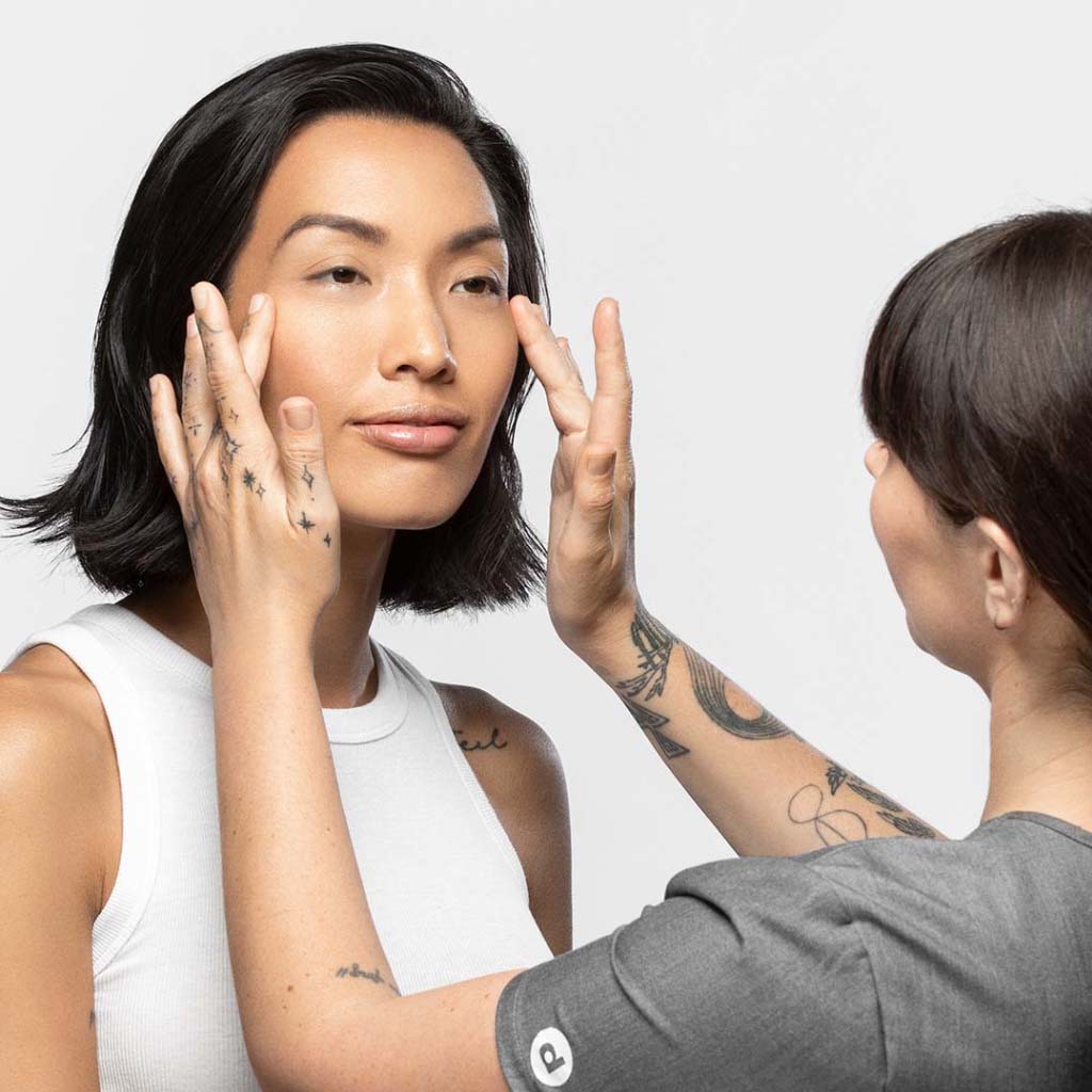Eine Person, die an einer anderen Person eine Gesichtspflege durchführt