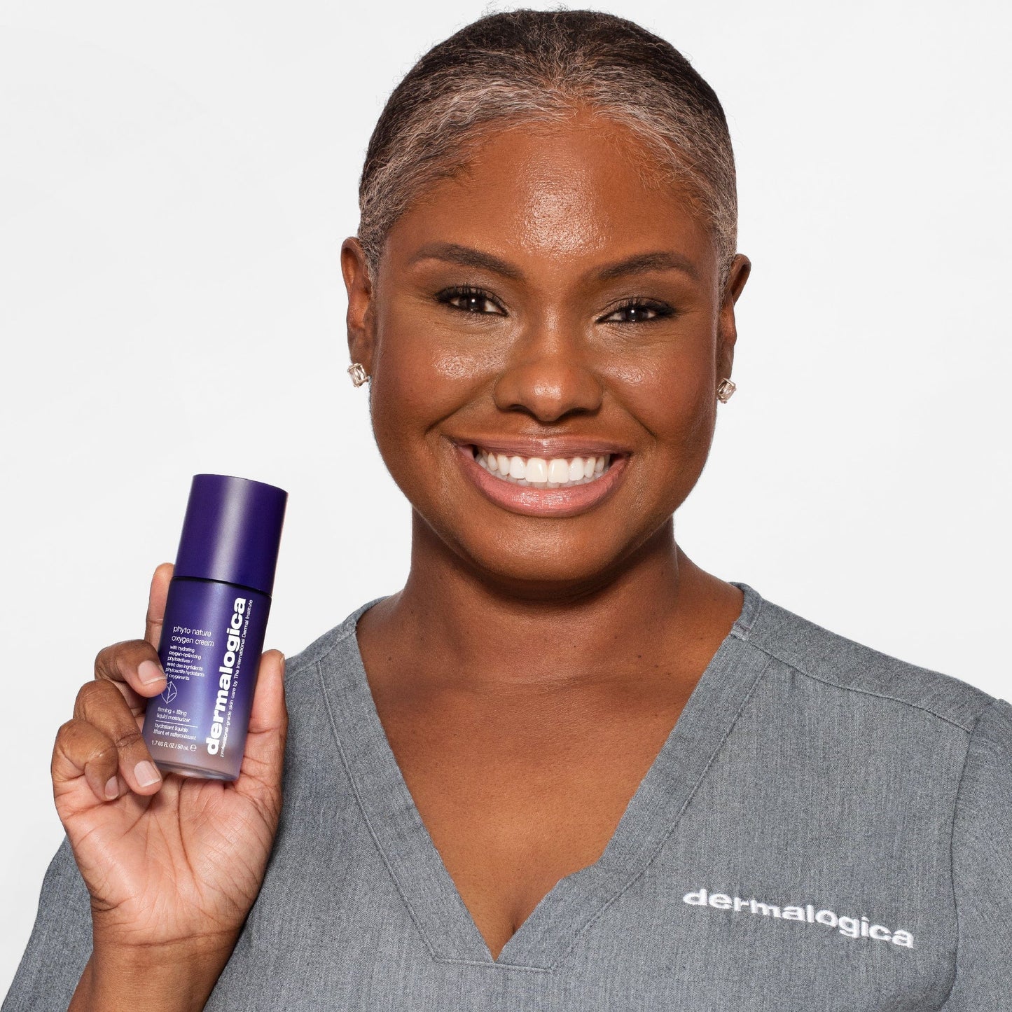 Frau mit strahlendem Lächeln hält eine Flasche -Hautpflegeprodukt.